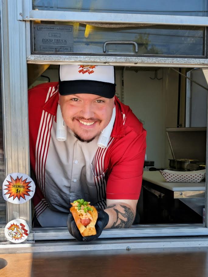 Brandon serving a hot dog